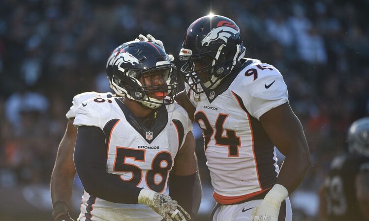 Denver Broncos outside linebacker Von Miller is congratulated by defensive end DeMarcus Ware on the field.