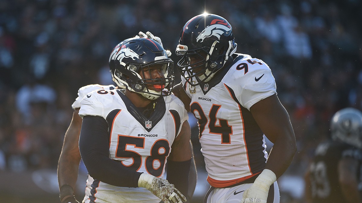 Denver Broncos outside linebacker Von Miller is congratulated by defensive end DeMarcus Ware on the field.