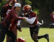 Washington Commanders linebacker Von Miller drives past a coach holding a blocking pad during a training camp drill.