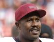 Washington Commanders outside linebacker Von Miller smiles in a burgundy team cap as he walks off the field.