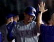 Texas Rangers left fielder Wyatt Langford exchanges high fives with teammates in the dugout after a home run.