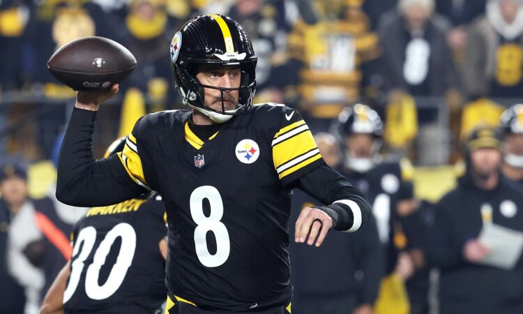 Pittsburgh Steelers quarterback Aaron Rodgers cocks the ball behind his head as he prepares to throw.