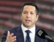 ESPN reporter Adam Schefter speaks on a broadcast set before a college football game at NRG Stadium.