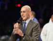 NBA commissioner Adam Silver holds a microphone and speaks on the floor after the All-Star Game.