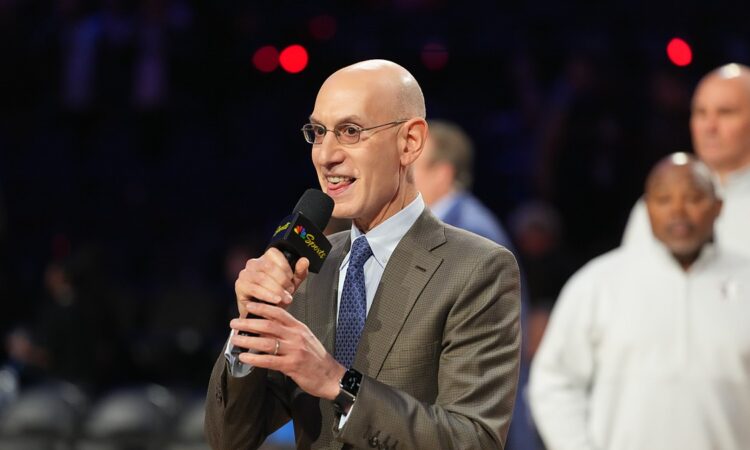 NBA commissioner Adam Silver holds a microphone and speaks on the floor after the All-Star Game.