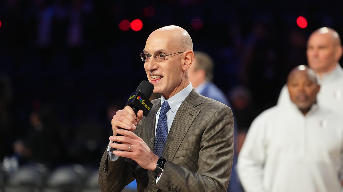 NBA commissioner Adam Silver holds a microphone and speaks on the floor after the All-Star Game.