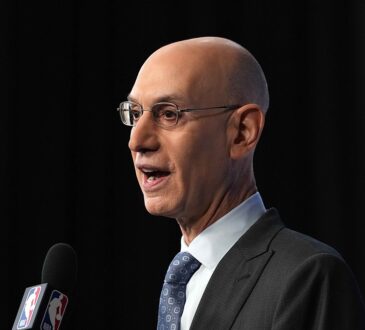 NBA commissioner Adam Silver speaks into an NBA-branded microphone at a press conference.