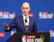 NBA commissioner Adam Silver gestures with one hand while speaking at an NBA Cup podium.