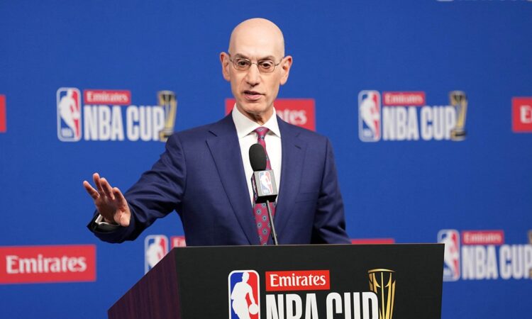 NBA commissioner Adam Silver gestures with one hand while speaking at an NBA Cup podium.