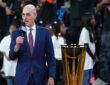 NBA commissioner Adam Silver speaks into a microphone beside the Emirates NBA Cup trophy on the court.