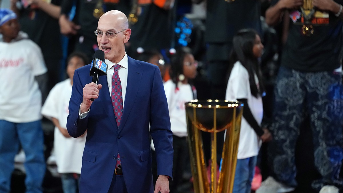 NBA commissioner Adam Silver speaks into a microphone beside the Emirates NBA Cup trophy on the court.