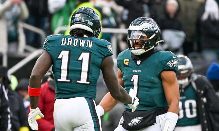 Philadelphia Eagles wide receiver A.J. Brown and quarterback Jalen Hurts celebrate on the field at Lincoln Financial Field.