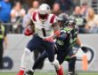 New England Patriots wide receiver A.J. Brown carries the ball as a Seattle defender grabs at him.