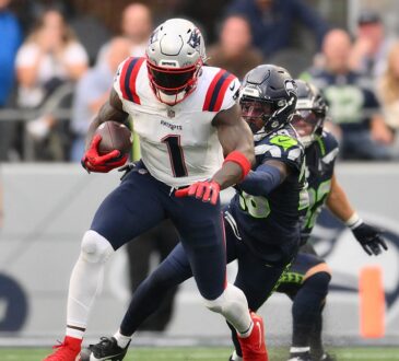 New England Patriots wide receiver A.J. Brown carries the ball as a Seattle defender grabs at him.