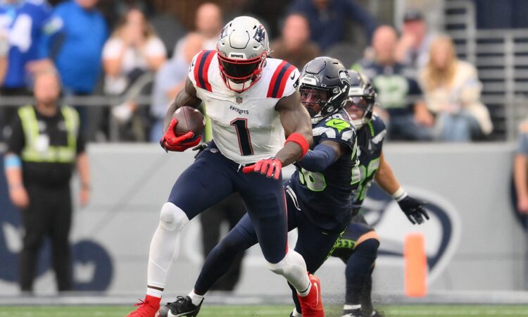 New England Patriots wide receiver A.J. Brown carries the ball as a Seattle defender grabs at him.