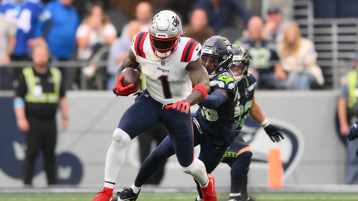 New England Patriots wide receiver A.J. Brown carries the ball as a Seattle defender grabs at him.