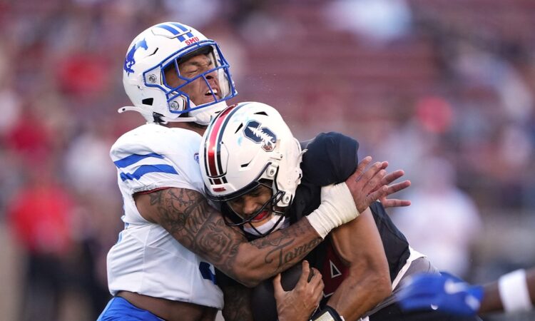 SMU Mustangs linebacker Alexander Kilgore tackles Stanford Cardinal quarterback Ashton Daniels around the shoulders.