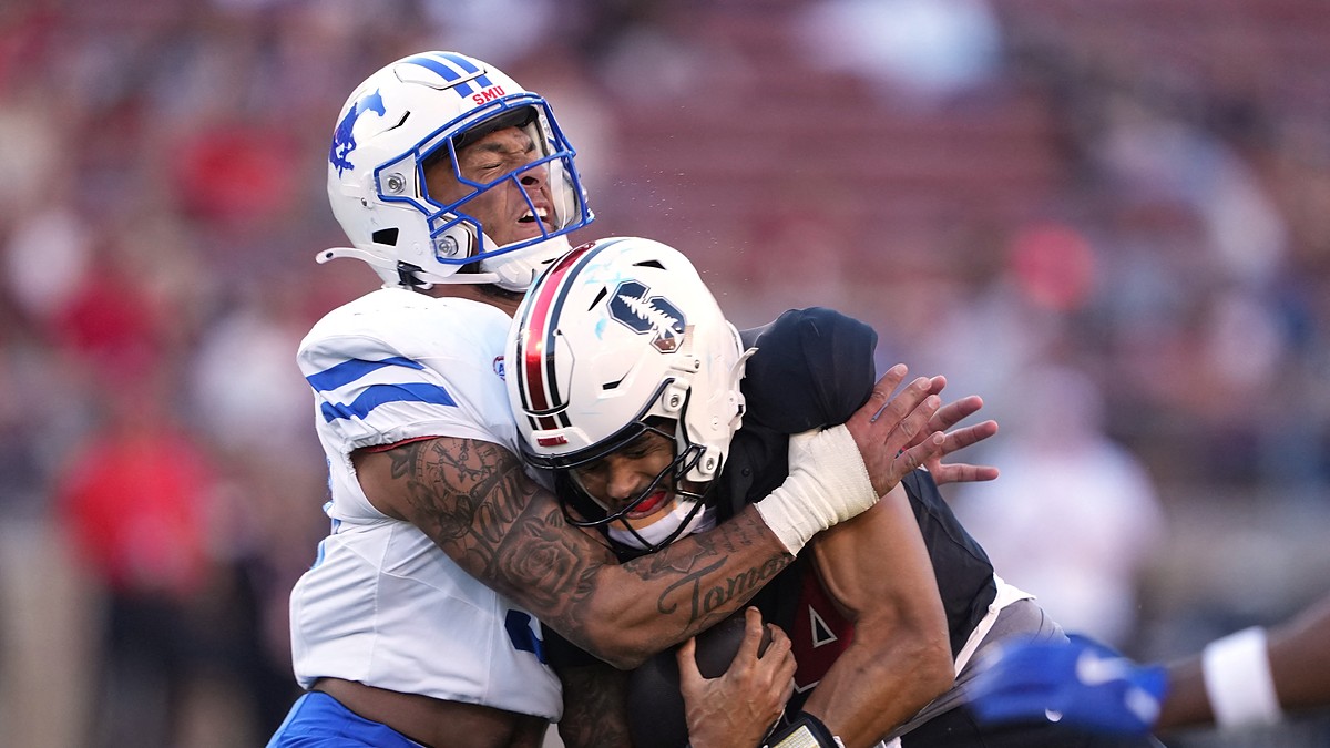 SMU Mustangs linebacker Alexander Kilgore tackles Stanford Cardinal quarterback Ashton Daniels around the shoulders.