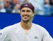Alexander Zverev of Germany grins with his arms spread after winning a match.