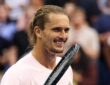 Alexander Zverev of Germany smiles with his racket raised beside his face after a match.