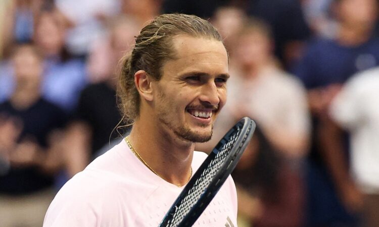 Alexander Zverev of Germany smiles with his racket raised beside his face after a match.