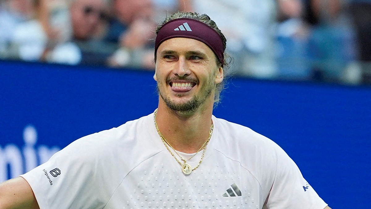 Alexander Zverev of Germany grins with his arms spread after winning a match.
