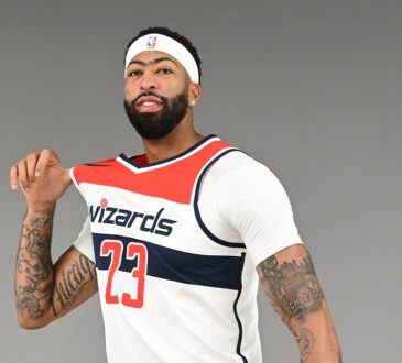 Washington Wizards forward and center Anthony Davis tugs on his No. 23 white home jersey while posing for a portrait.