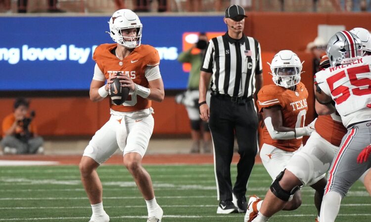 Texas Longhorns quarterback Arch Manning holds the ball at his chest and scans downfield against Ohio State.