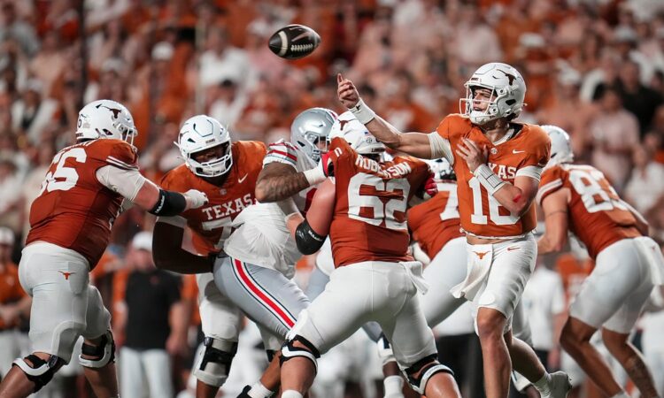 Texas Longhorns quarterback Arch Manning releases a pass from the pocket as linemen block against Ohio State.