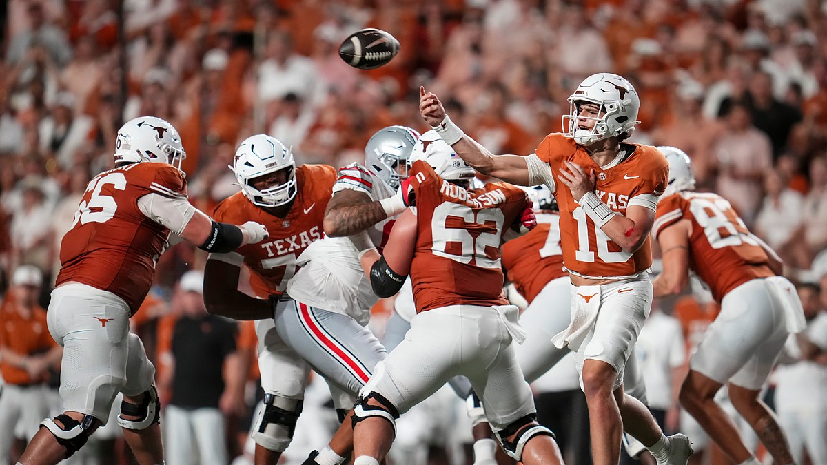 Texas Longhorns quarterback Arch Manning releases a pass from the pocket as linemen block against Ohio State.