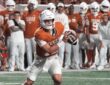 Texas Longhorns quarterback Arch Manning rolls out with the ball in both hands as a UTSA defender closes in.