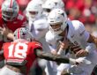 Ohio State Buckeyes safety Jaylen McClain reaches to tackle Texas quarterback Arch Manning as he runs with the ball.