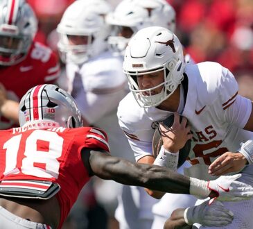 Ohio State Buckeyes safety Jaylen McClain reaches to tackle Texas quarterback Arch Manning as he runs with the ball.