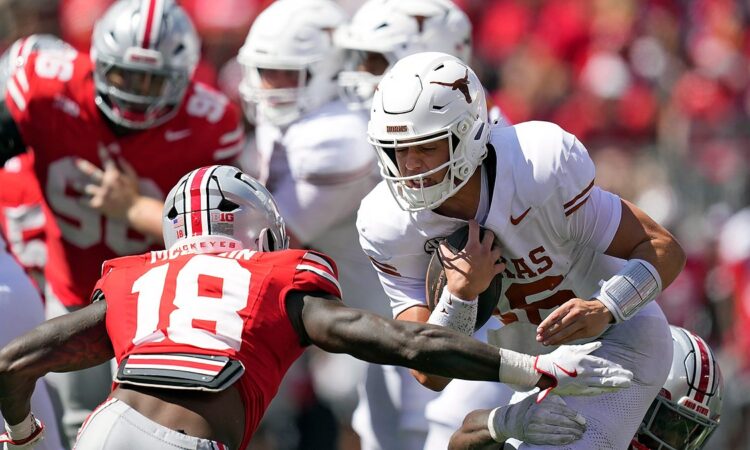 Ohio State Buckeyes safety Jaylen McClain reaches to tackle Texas quarterback Arch Manning as he runs with the ball.