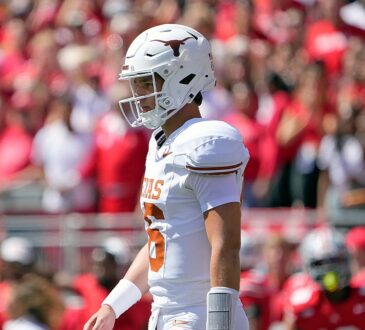 Texas Longhorns quarterback Arch Manning walks back toward the huddle in front of the Ohio State crowd.