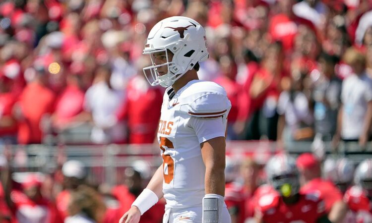 Texas Longhorns quarterback Arch Manning walks back toward the huddle in front of the Ohio State crowd.