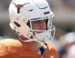 Texas Longhorns quarterback Arch Manning stands in profile in his helmet during pregame warmups.