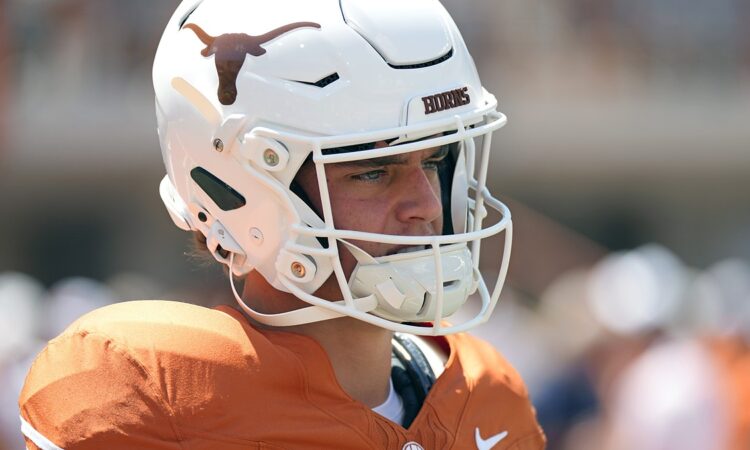 Texas Longhorns quarterback Arch Manning stands in profile in his helmet during pregame warmups.