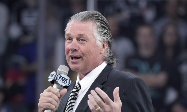 Former Los Angeles Kings coach Barry Melrose speaks into a microphone during a pregame ceremony.