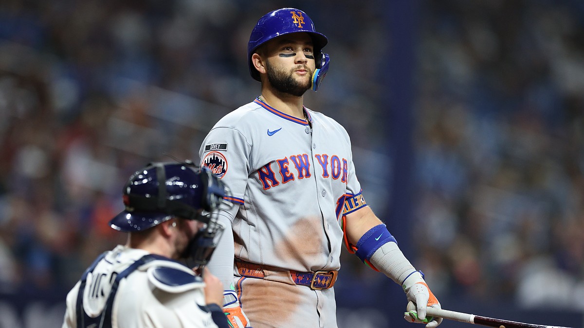 New York Mets third baseman Bo Bichette stands at the plate holding his bat as the Tampa Bay Rays catcher looks away.