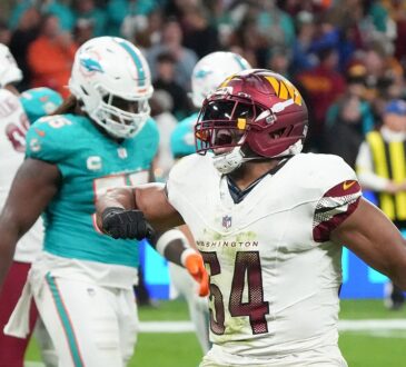Commanders linebacker Bobby Wagner shouts and flexes after a play against the Dolphins.