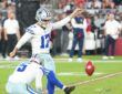 Dallas Cowboys place kicker Brandon Aubrey follows through on a field goal as his holder kneels beside him.