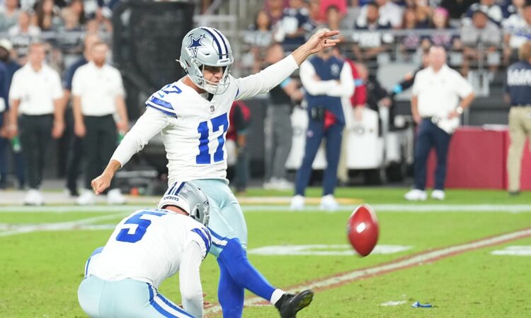 Dallas Cowboys place kicker Brandon Aubrey follows through on a field goal as his holder kneels beside him.