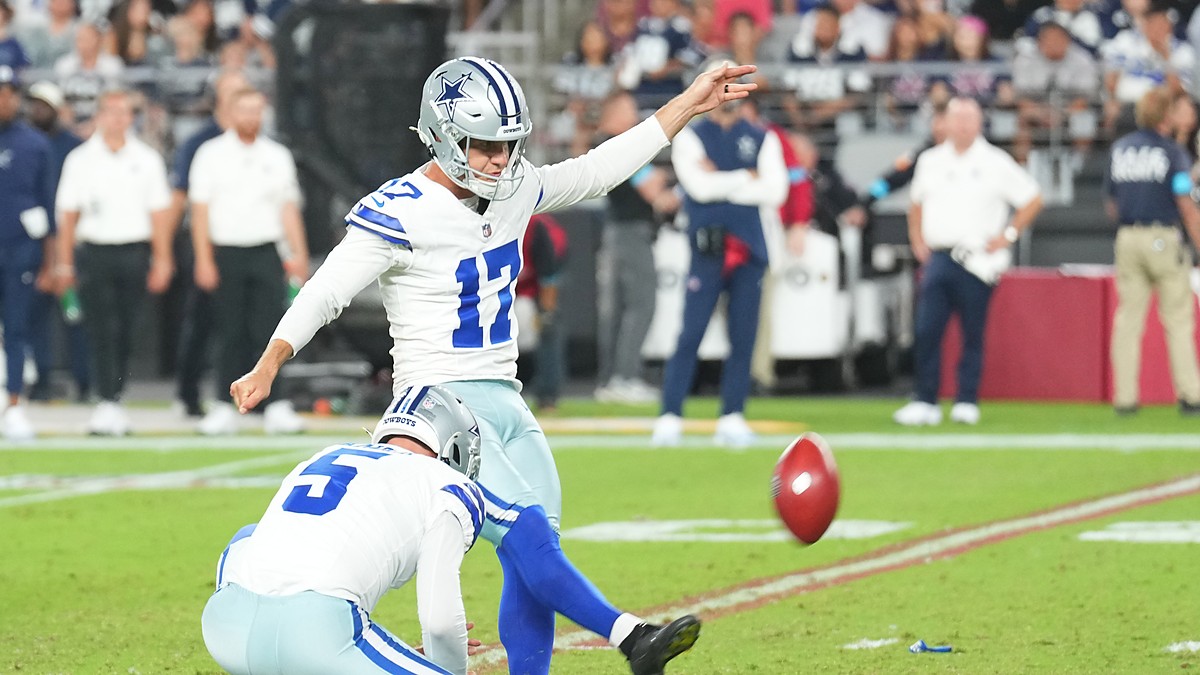 Dallas Cowboys place kicker Brandon Aubrey follows through on a field goal as his holder kneels beside him.