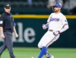 Texas Rangers right fielder Brandon Nimmo runs toward second base after an RBI double as the umpire looks on.