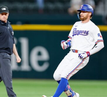 Texas Rangers right fielder Brandon Nimmo runs toward second base after an RBI double as the umpire looks on.