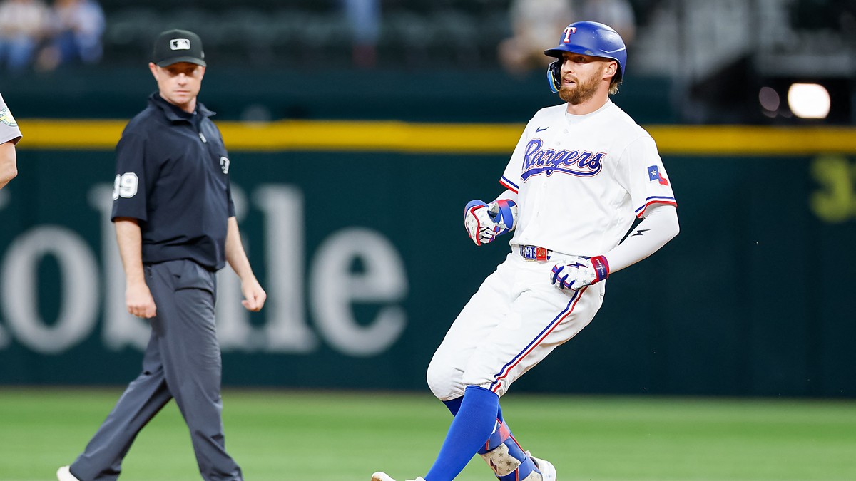 Texas Rangers right fielder Brandon Nimmo runs toward second base after an RBI double as the umpire looks on.