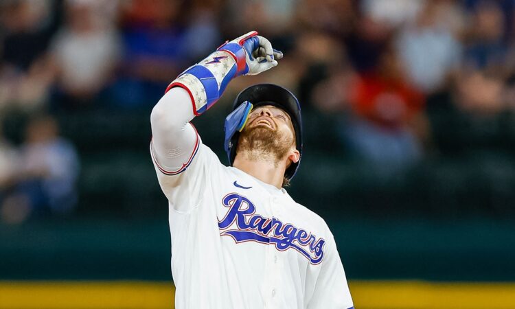 Texas Rangers right fielder Brandon Nimmo points skyward at second base after an RBI double at Globe Life Field.