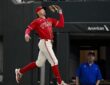 Texas Rangers right fielder Brandon Nimmo reaches up with his glove to catch a foul ball on the run.