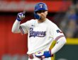 Texas Rangers right fielder Brandon Nimmo stands at second base and points one finger in the air.